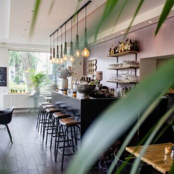 Interior Shot Of A Cafe With Chairs Near The Bar With Wooden Tables